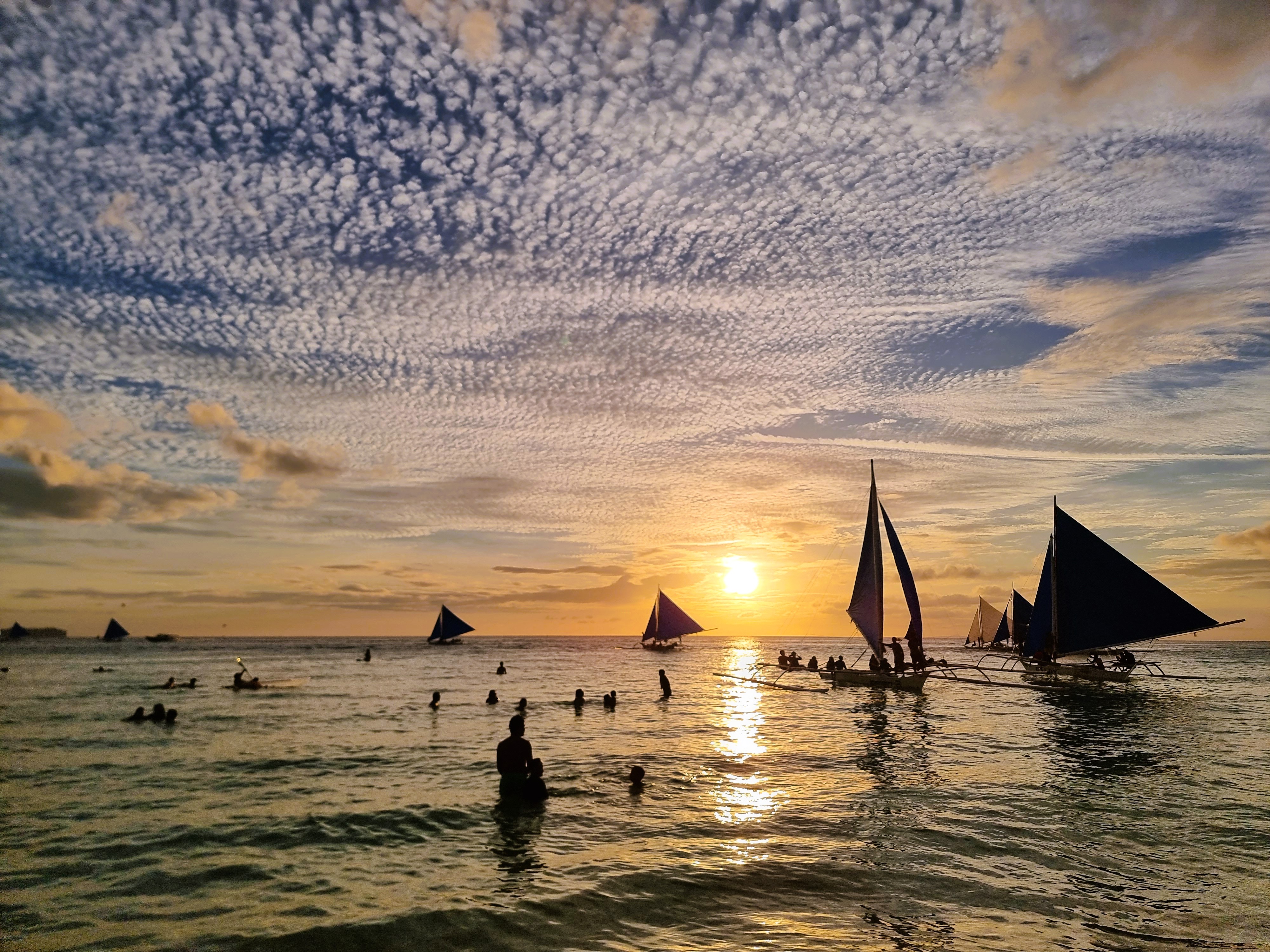 Golden hour on the water with traditional sailboats